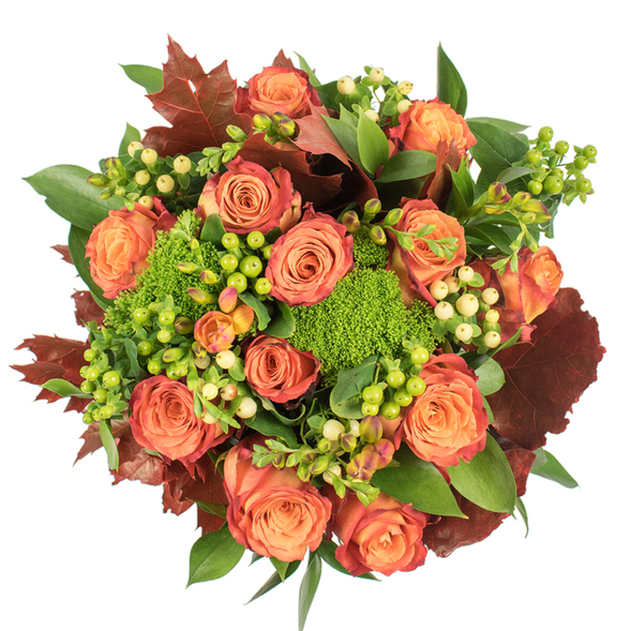 Framed from above on a clean white plane, this autumn-inspired bouquet is a study in warm colour gradients and tactile variety. The central roses command attention: large, fully opened blooms transition from a soft, honeyed peach at their cores to richer coral and deep orange at the outer petals, many edged with a subtle reddish-rust that gives them the look of fallen leaves. Nestled closely among these are clusters of Hypericum berries - crisp lime greens next to creamy, pale-yellow beads - that create lively visual punctuation and a pleasing, almost playful contrast in shape. The arrangement's green trick dianthus (or a similar textured filler) forms plush, moss-like clusters that bring an unexpected, dense texture and a bright green counterbalance to the warmer tones. Supporting foliage ranges from glossy, broad green leaves that add sheen and structure to larger, lobed leaves in burgundy and burnt orange which echo late-season maples and ground the palette. Carefully arranged in a lush, circular silhouette, the bouquet shows deliberate layering: blooms at varying heights, berries popping through the midplane, and deeper leaves tucked to create depth. Light falls softly across the composition, highlighting velvet petals and casting delicate shadows that define the bouquet's sculptural quality. This piece evokes the gentle comforts of autumn - perfect for a Thanksgiving table, a cosy home display near a window on Dartmouth Road, or a heartfelt gift delivered across Forest Hill and neighbouring Honor Oak, bringing seasonal colour and tactile richness into any interior.